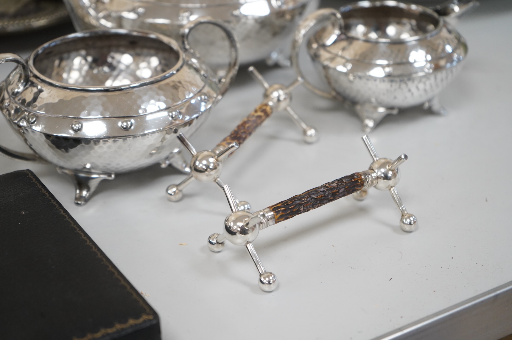 A collection of silver plate to include cased dessert forks, a hammered tea pot, pair of candlesticks and a salver